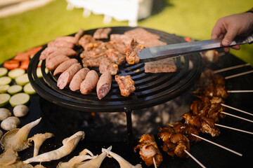 The chef grills meat and vegetables in the backyard
