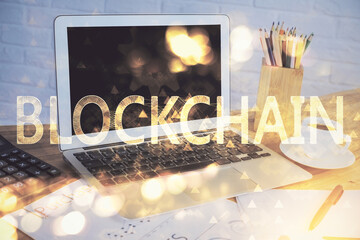 Double exposure of blockchain and crypto economy theme hologram and table with computer background....