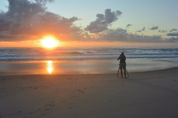 Photographer capturing beach sunrise