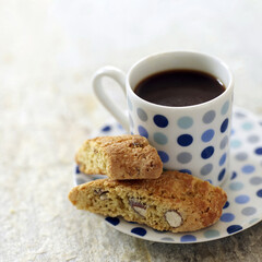 Italian espresso in spotty blue cup with cantuccini biscuits
