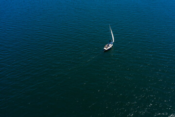 aerial view of a lonely white sailing yacht at sea