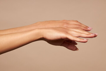  Health and beauty. Female hands on a beige background without a cassette.