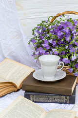 cup coffee (tea), books and bouquet flax in wicker basket