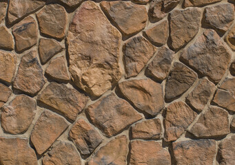 Fragment of a wall made of brown stones of various shapes