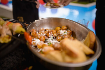 Young baked potatoes in sauce and toast in a bowl