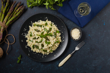 Classic Italian risotto with asparagus. Top view. Darkblue background.