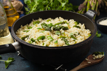 Classic Italian risotto with asparagus. Front view. Darkblue background.