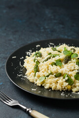 Classic Italian risotto with asparagus. Front view. Darkblue background.