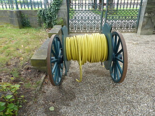 Water hose reel with yellow water hose. Hanover, Germany