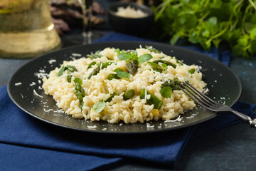 Classic Italian risotto with asparagus. Front view. Darkblue background.