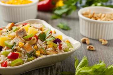Salad with rice, chicken, peanuts and vegetables. Front view.