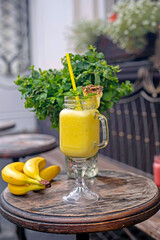 Cool smoothie with pineapple, mango, banana and mint on wooden background
