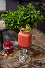 Cool smoothie with raspberries on a wooden background