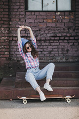 trendy girl in hat with skateboard