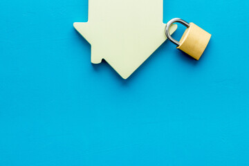 Security concept. House and lock on blue background top view copy space