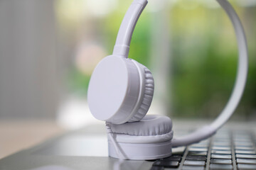Obraz na płótnie Canvas Headphones over laptop on wooden desk table. Music concept