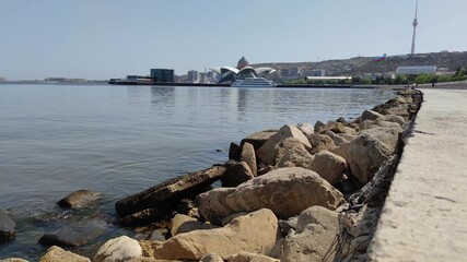 Fototapeta na wymiar Seaside breakwater. Caspian sea with Baku cityscape in the background. Baku, Azerbaijan