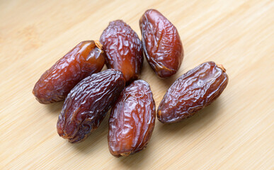 Dried dates on the wooden background.
