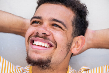 Obraz premium Close up cheerful young african american mixed race man with hands behind head