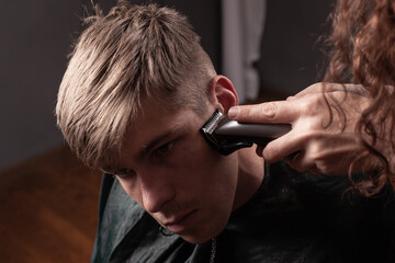 men's haircut, cutting the temporal lobe with a clipper close-up