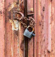 Lock on a chain on a rusty metal container