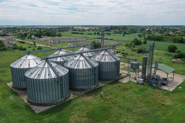 Fototapeta na wymiar Agricultural silos on the farm, close-ups from above with a drone. Farm Industrial granary, elevator dryer, building exterior, storage and drying of cereals, wheat, corn, soybeans, sunflowers.