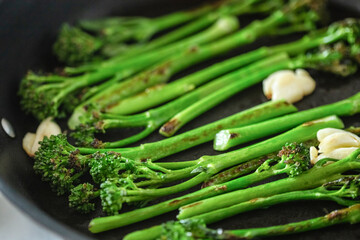 Cooking broccolini in a fried pan.