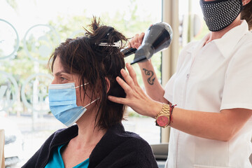 Señora arreglando su cabello con medidas covid-19