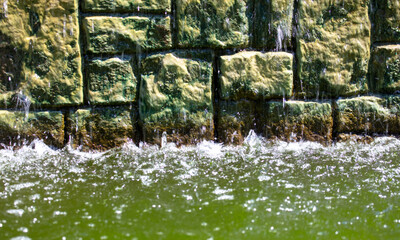 Water flows along a brick wall.