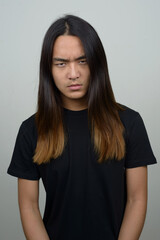 Stressed young Asian man with long hair