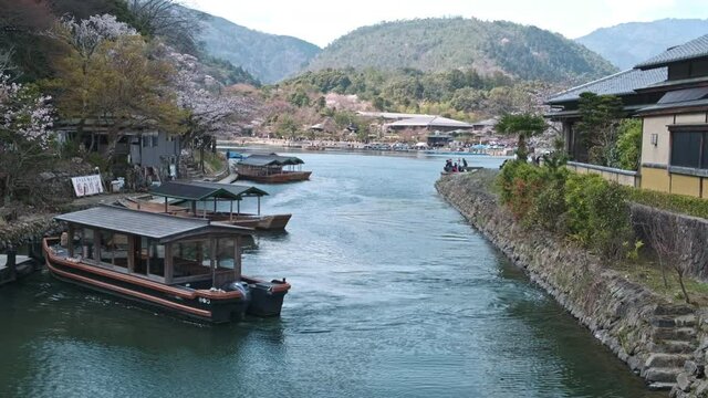 Beautiful river with traditional japanese tourist boats in Arashiyama, Kyoto. Cherry blosom bloom.
