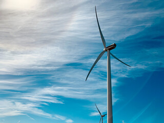 A windmill isolated on a cloudy blue day sky in Holland, wind turbine, energy