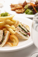 Club sandwich and bruschetta served with chicken wings in the background