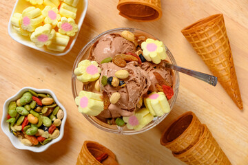top view bowl of chocolate flavor ice cream with marshmallows and various nuts