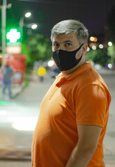 
A man in a medical black mask at night on the street