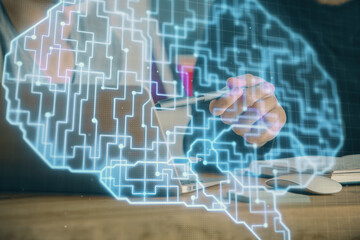 Businessman with computer background with brain theme hologram. Concept of brainstorm. Multi exposure.