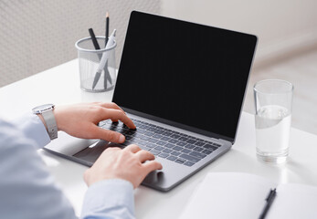 Work online remotely. Businessman uses laptop from blank screen