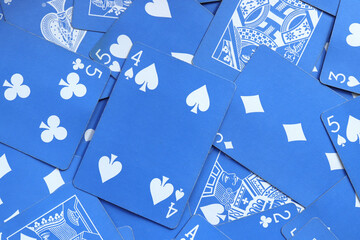 Many miscellaneous jumbled blue playing cards surface. Mixed playing cards background. Assorted...
