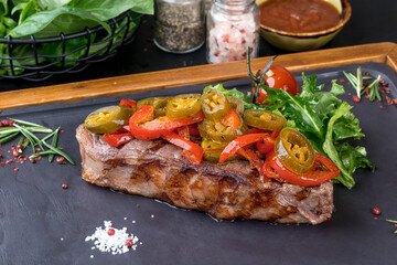 Grilled steak served on a black slate board