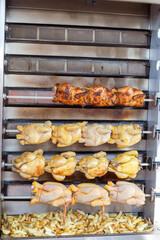 Chicken and potatoes in grill getting baked