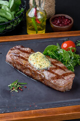 Grilled steak served on a black slate board