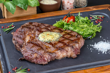 Grilled steak served on a black slate board
