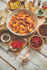 Traditional fried tiger prawn with garlic bread as top view served in a white frying pan