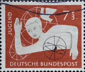 GERMANY - CIRCA 1956: This postage stamp in brown shows a boy with different symbols on a charity...