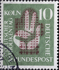 GERMANY - CIRCA 1956: This postage stamp in green shows a hand raised to the oath in front of the...