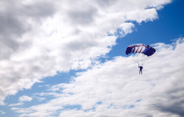 skydiver high in the clouds, blue streak of sky