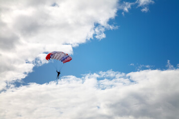 Fototapeta na wymiar skydiver high in the clouds, blue streak of sky