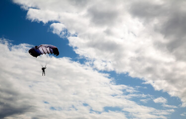 skydiver high in the clouds, blue streak of sky