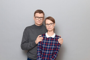 Portrait of man and woman with serious expressions and with glasses