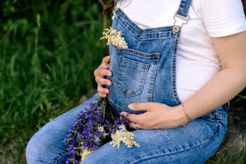 pregnant woman holding belly with flowers